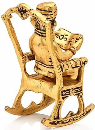 Back angle view of a handcrafted metal Ganesha idol sitting on a rocking chair, reading the Ramayan.