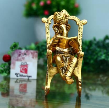 Front view of a golden Ganesha idol reading the Ramayan on a rocking chair, handcrafted for home decor.